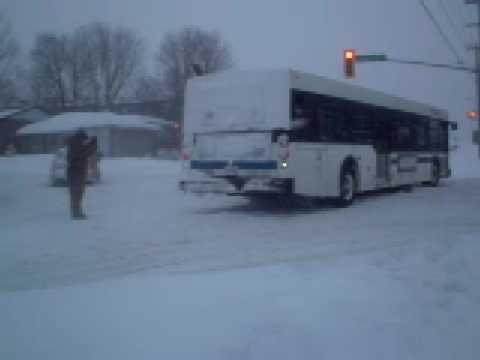 **I APOLOGIZE FOR THE SWEARING!!** :( we got over 20cm. of snow in 5 hours in a major winter storm in Barrie, ON. My friend and I were walking to work in this blast of wintery weather, when we come across a Barrie Transit bus stuck in the middle of a normally busy intersection. He was there for a good 35 minutes, just sitting there. I pulled out my camera, and taped this driver JUST as he tried to get out of this snow drift. The first person trying to help the driver get out is ANOTHER Barrie Transit Driver, (a very impatient one) which soon gives up on trying to help his fellow co-worker get out. Then, a random civillian who drives 18-wheelers for a living approaches to ACTUALLY help the driver get outta this intersection and on with his route. Watch the video, and note that my friend and I apologize for the swearing and any inmaturity that may have happened I also hope this guy who did get the driver on his way know's that he is a great civillian! I hope he is watching this right now :) I love how the rivers of the cars at the end give him credit by honking their horns :)
