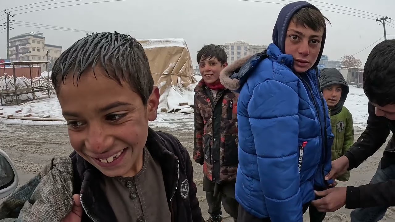 При температуре -12 градусов по Цельсию афганские дети-беженцы дрожали от холода, рыская в тапочк...