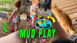 Little Girl Plays In Mud And Water With Her Cat