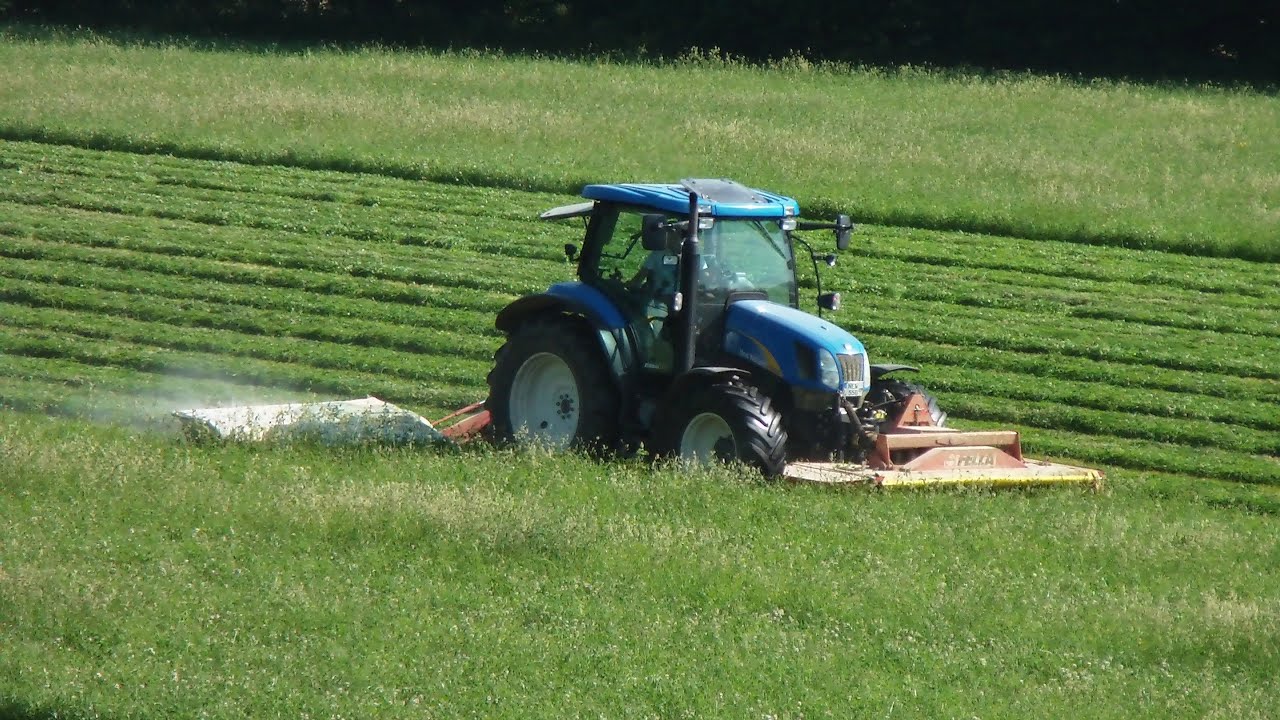 Heuernte Teil 1 New Holland Traktor mit Front und Heck Mähwerk in