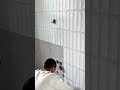 applying grout and cleaning the tiles on the wall to ensure a smooth and finished appearance today