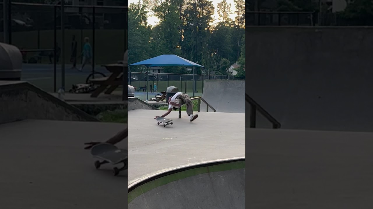 Skateboarder does 360 flip up ramp then attempts to board slide rail and falls on back at skatepark