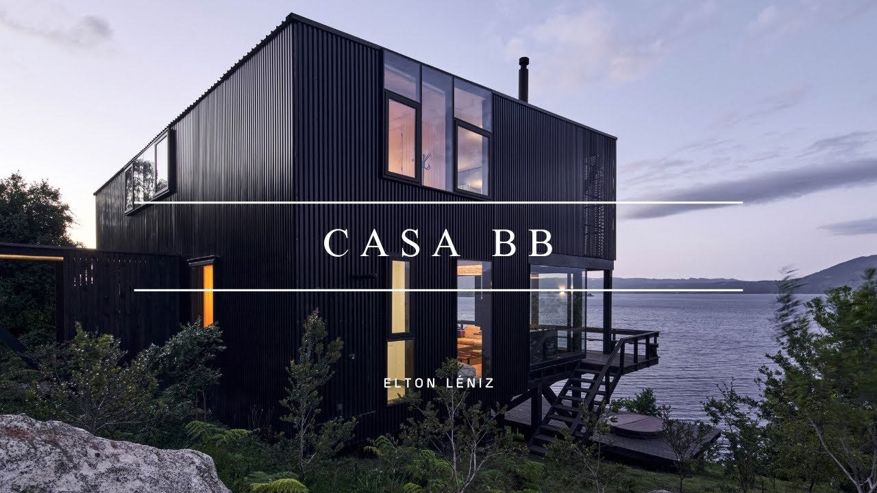 Дизайн черного дома на сваях на склоне холма с видом на озеро