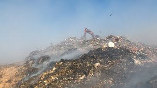 Garbage at dump ground. Excavator segregating garbage | stock footage | stock video | Cinefootage