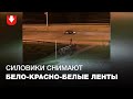 Силовики снимают бело-красно-белые ленты с ограждения