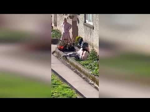 Video shows raging Scots neighbours brawling before one tumbles into garden with trousers her ankles