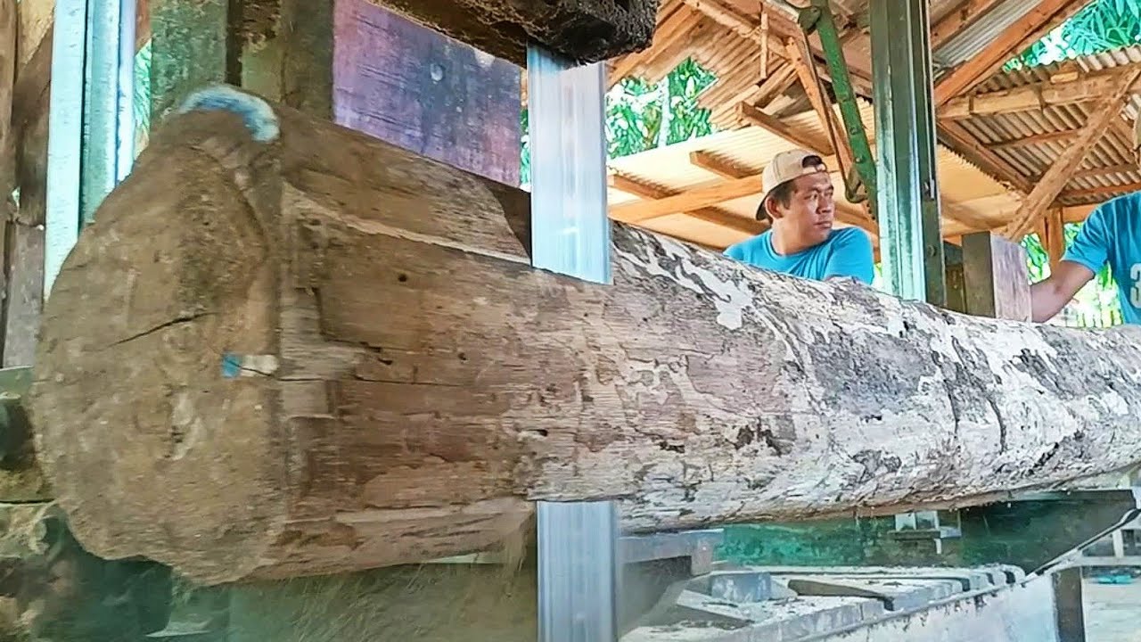 sawing dry teak wood full of old fibers into frame blocks measuring 7× ...