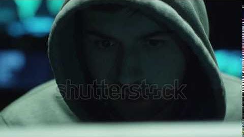 Male hacker working on a computer while green code | Video Footage | Shutterstock