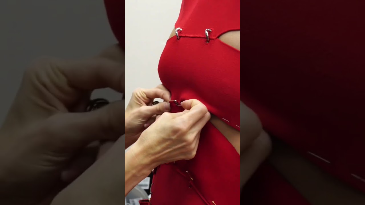 The Design Team pin together knit strips to assemble the slashed dress with metal ring detailing.