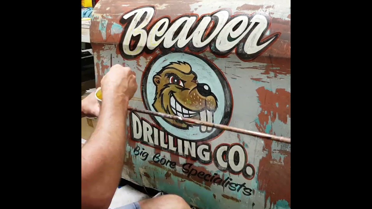 Signwriting a patina door for shed art.  