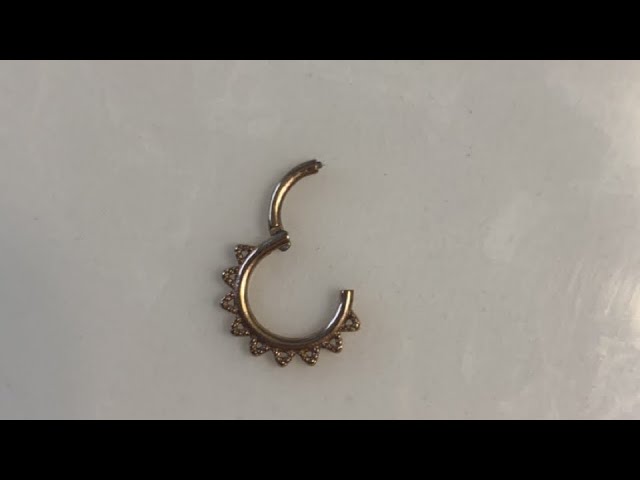 Please help me get this septum clicker out. It has only a small intent with  which to open it and I can't get it out with my nails or a tweezer. 