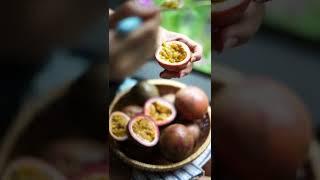 A Person Scooping Out Sliced Passion Fruits
