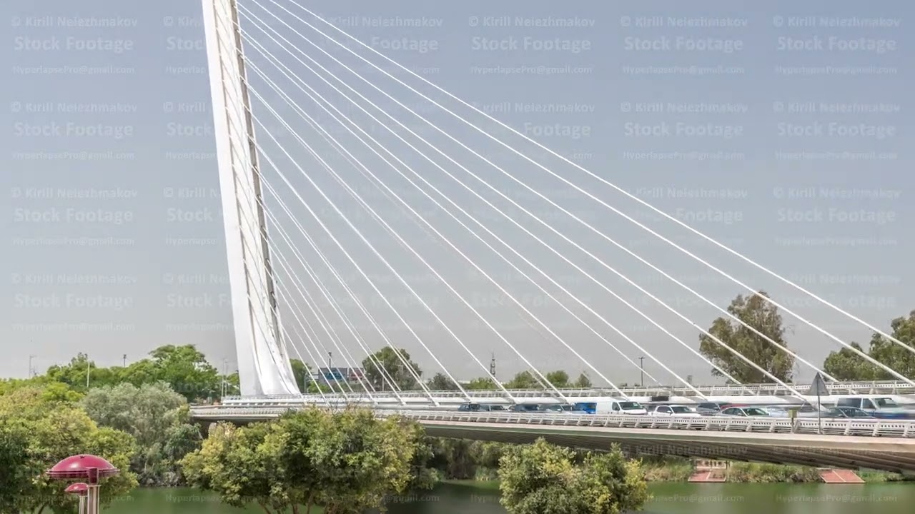 Alamillo Bridge with tall pylon and steel cables crossing over Guadalquivir River timelapse