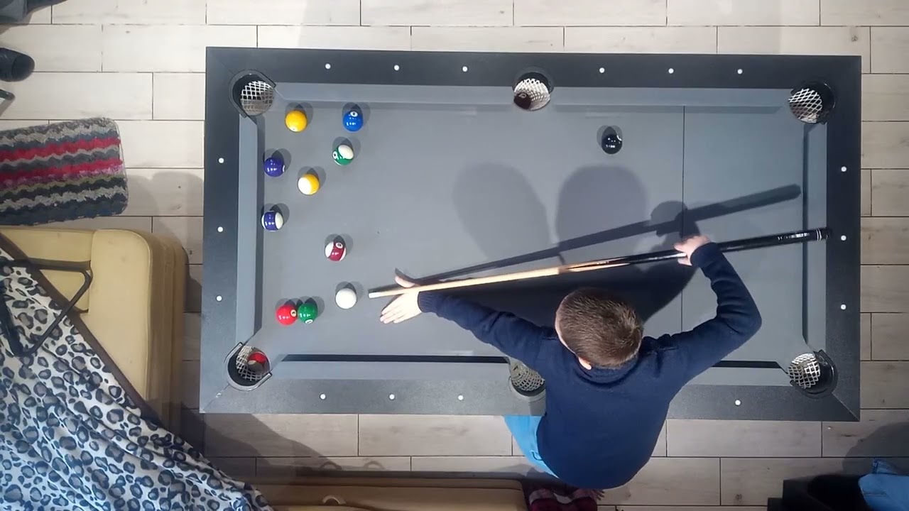 Ребёнок учится играть б американский бильярд дома 