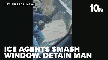 Video shows ICE agents smashing car window, detaining man