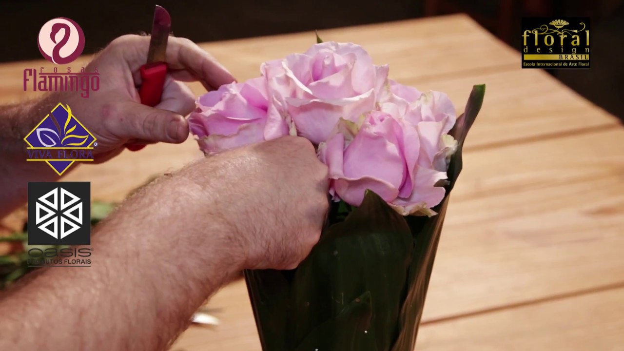 Arranjo de flores com rosas e folhas de aspiditra em cones