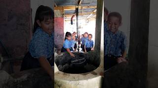 anak-anak menimba air di sumur