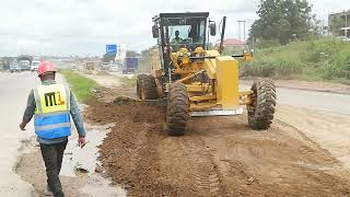 Caterpillar Grader Operator taking out excess material from  existing road and level onto the should
