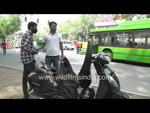 Repairing a scooter amid traffic on a Delhi roadside