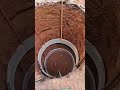 Crew lowers concrete well pipes with thick ropes