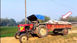 Eicher 242 tractor carrying a trolley fully loaded with cement.