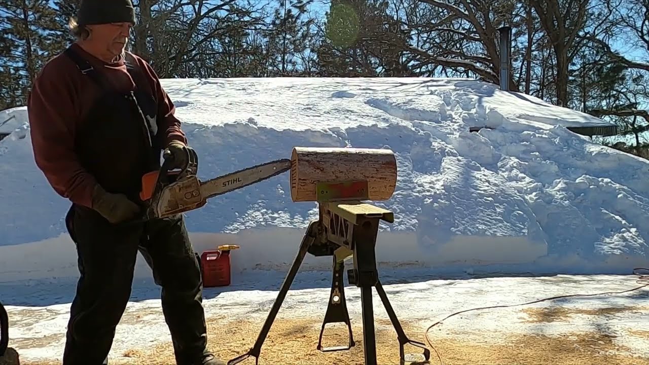 Chainsaw carving a rustic bird house.