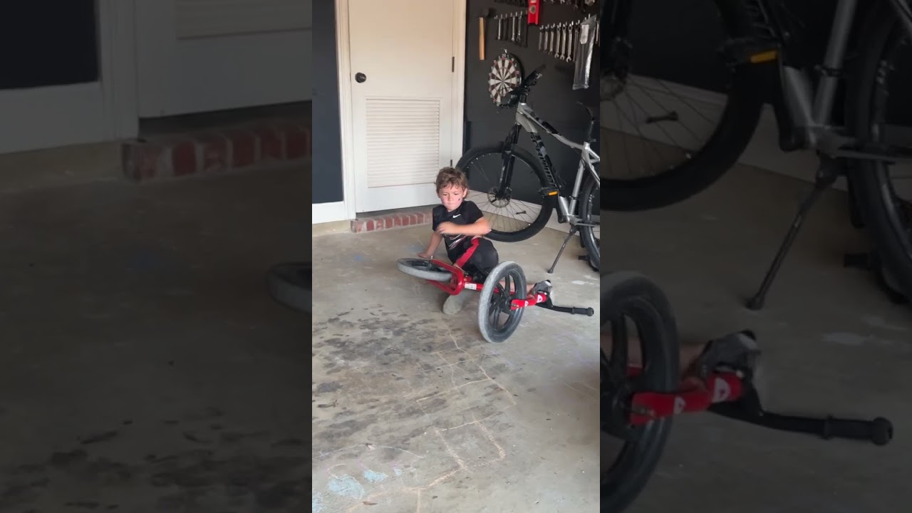 Boy rides bike up ramp in garage but doesn't pull up then falls forward and faceplants