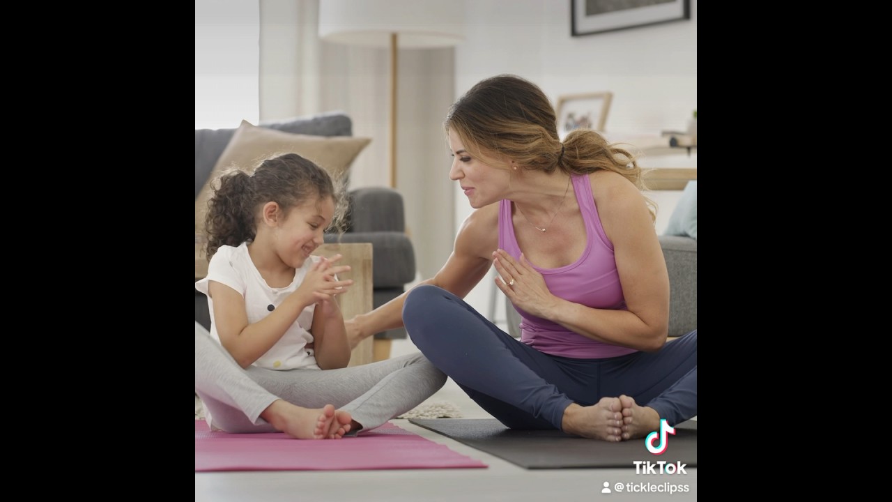 Mom tickling daughter doing yoga 
