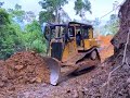 Bulldozer Pushing Heavy Soil on Steep Jungle Road