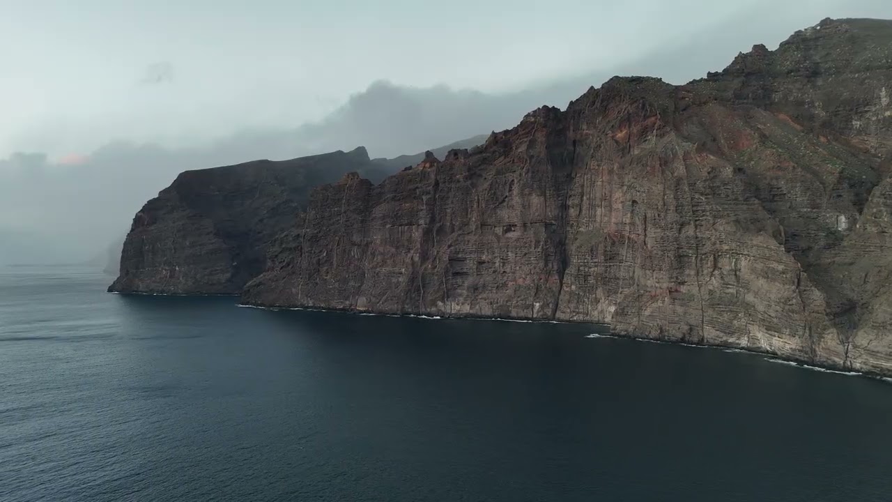 Aerial Drone View of Los Gigantes Cliffs Rising from the Ocean at Sunset