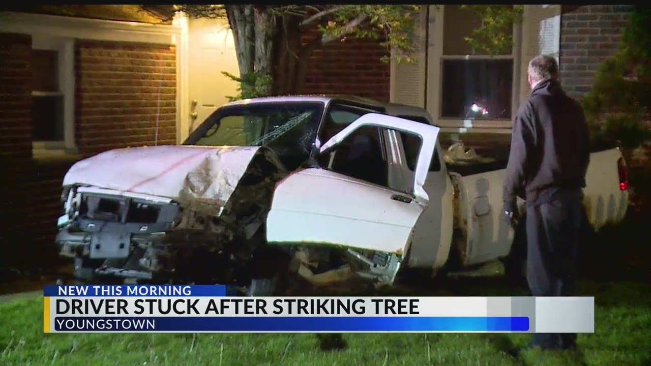 Driver stuck between tree and fence after crash - YouTube