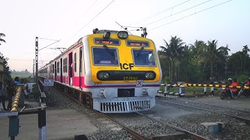 Super speedy modern ICF EMU local train furiously passing through level crossing