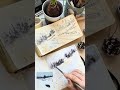Watercolor process of painting snowy landscape with small house in the Carpathian Mountains