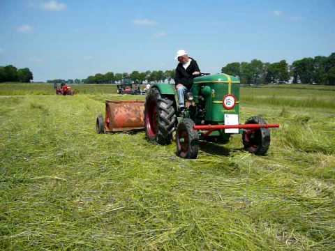 Een medewerker van Historisch Loonwerk uit Ens schudt hier met een Deutz en een Kemper trommelschudder het net gemaaide gras op Schokland. Dit in het kader van de maaiwedstrijden op 13 juni ...