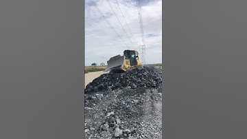 Heavy machine Bulldozers extremely pushing rock on construction site.