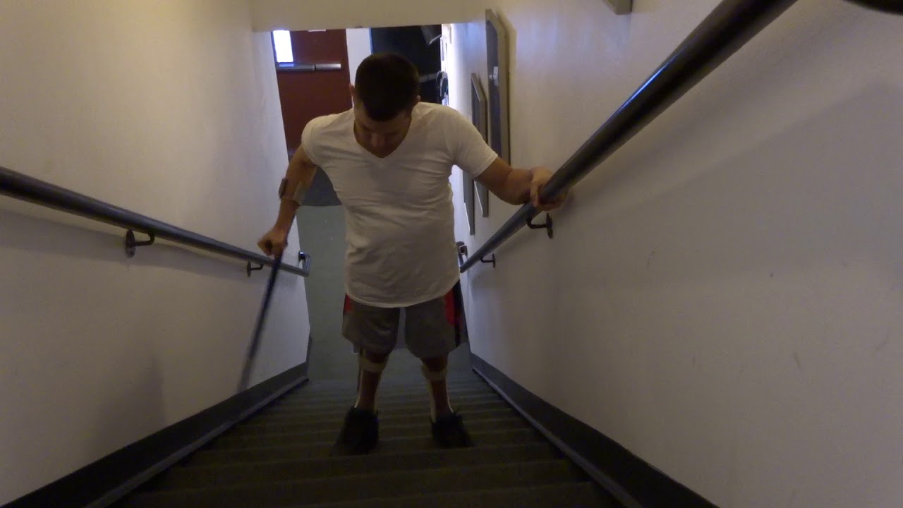 Walking Up Stairs With Leg Braces and Crutches Front View (Wheelchair