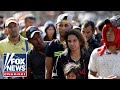Tucker takes on Univision anchor over migrant caravan
