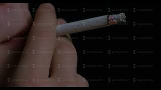 Man smoking cigarette on black background Close up portrait of young man smoking