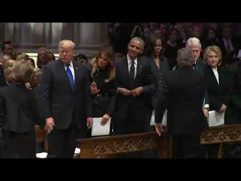 George W. Bush hands Michelle Obama a piece of candy at funeral for George H.W. Bush