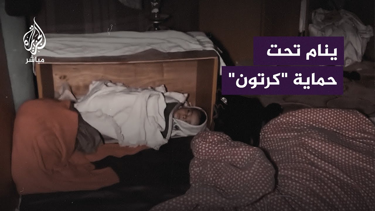 عائلة فلسطينية نازحة تحاول حماية طفلها من الأمطار "بالكرتون"