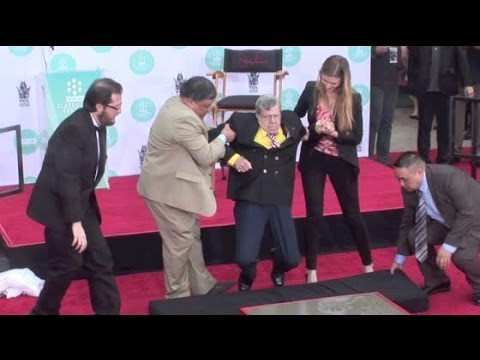 JERRY LEWIS supported by staffers when legs almost fail him