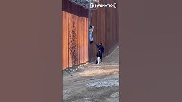 Smuggler helps migrant family cross over U.S. border fence