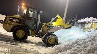 Cat 906 plowing snow with metal pleas.
