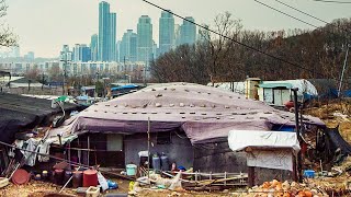 Guryong Village: South Koreas Biggest Slum
Guryong Village is a shantytown right across the street from Gangnam District, the most affluent part of South Korea. Together they represent one of the starkest divides between rich and poor within the same city - but how exactly did this come to be? The answer shows just how inextricable the two really are.
Please consider a donation to our Patreon, to help fund the development of more Anomalies: https://www.patreon.com/AnomalyDocumentaries
This episode wouldnt be possible without the help of Simpli City and The Seoul Guide, two channels which graciously permitted the use of raw footage that you see. Check them out and give them a subscription if you like city walks:
https://www.youtube.com/channel/UCs6VAFvuR2D2uoXgHEnYQ5g/videos
https://www.youtube.com/user/TheSeoulGuide
Finally, the sources:
https://phmuseum.com/thekimsoohyun/story/guryong-village-in-seoul-1d1956bb9e
https://www.theguardian.com/cities/gallery/2014/jul/14/gangnam-shanty-style-life-in-seouls-guryong-village-slum-in-pictures
https://www.koreatimes.co.kr/www/news/nation/2014/12/116_169386.html
https://newsis.com/view/?id=NISX20170329_0014795520&cID=10202&pID=10200
https://books.google.ca/books?id=oWFyAwAAQBAJ&pg=PA87&redir_esc=y#v=onepage&q&f=false
https://web.archive.org/web/20150526070559/http://www.globalaging.org/elderrights/world/2005/city.htm
https://apnews.com/article/c22de3a565fe4e85a0508bbbd72c3c1b
https://web.archive.org/web/20150520105851/http://iamkoream.com/seoul-to-demolish-the-last-surviving-slum-in-the-ritzy-gangnam-district/
http://www.koreaherald.com/view.php?ud=20120208001264
https://www.koreatimes.co.kr/www/news/nation/2015/02/116_173154.html
https://koreajoongangdaily.joins.com/news/article/article.aspx?aid=2997235&cloc=rss%7cnews%7cjoongangdaily
https://www.bbc.com/news/world-asia-17456032
https://www.koreatimes.co.kr/www/news/nation/2014/06/116_159401.html
https://www.scribd.com/document/433505153/HHS-Guryong-Village-docx
https://www.intechopen.com/books/smart-urban-development/symmetrical-aspects-of-urban-regeneration-in-seoul
https://search.proquest.com/openview/eb8e1d100e649c8bcbfe7957dace4dcd/1?pq-origsite=gscholar&cbl=1566344
https://www.fdv.uni-lj.si/docs/default-source/tip/oblegano-dr%C5%BEavljanstvo-dru%C5%BEbena-konstrukcija-neenakosti-v-okro%C5%BEju-gangnam-v-seoulu.pdf?sfvrsn=0
https://tvshowdictionary.tistory.com/4724
https://www.upi.com/Archives/1981/09/30/Seoul-surprises-Nagoya-for-Olympic-bid/5566370670400/
https://search-proquest-com.proxy.queensu.ca/docview/2272174114?pq-origsite=primo
https://www.fdv.uni-lj.si/docs/default-source/tip/oblegano-dr%C5%BEavljanstvo-dru%C5%BEbena-konstrukcija-neenakosti-v-okro%C5%BEju-gangnam-v-seoulu.pdf?sfvrsn=0
https://www.ft.com/content/0957c9ba-343d-11e4-8832-00144feabdc0
http://www.koreaherald.com/view.php?ud=20171211000322
https://koreajoongangdaily.joins.com/news/article/article.aspx?aid=3045048 Guryong Village: South Koreas Biggest Slum