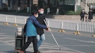 Kind hearted Chinese motorist helps blind man cross road