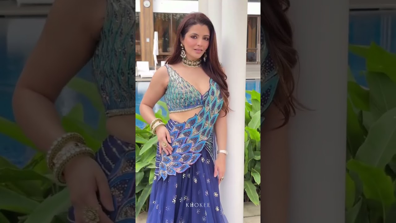 The Mirelle Saree shimmers in a deep oceanic navy and teal palette, draped in glistening leaves