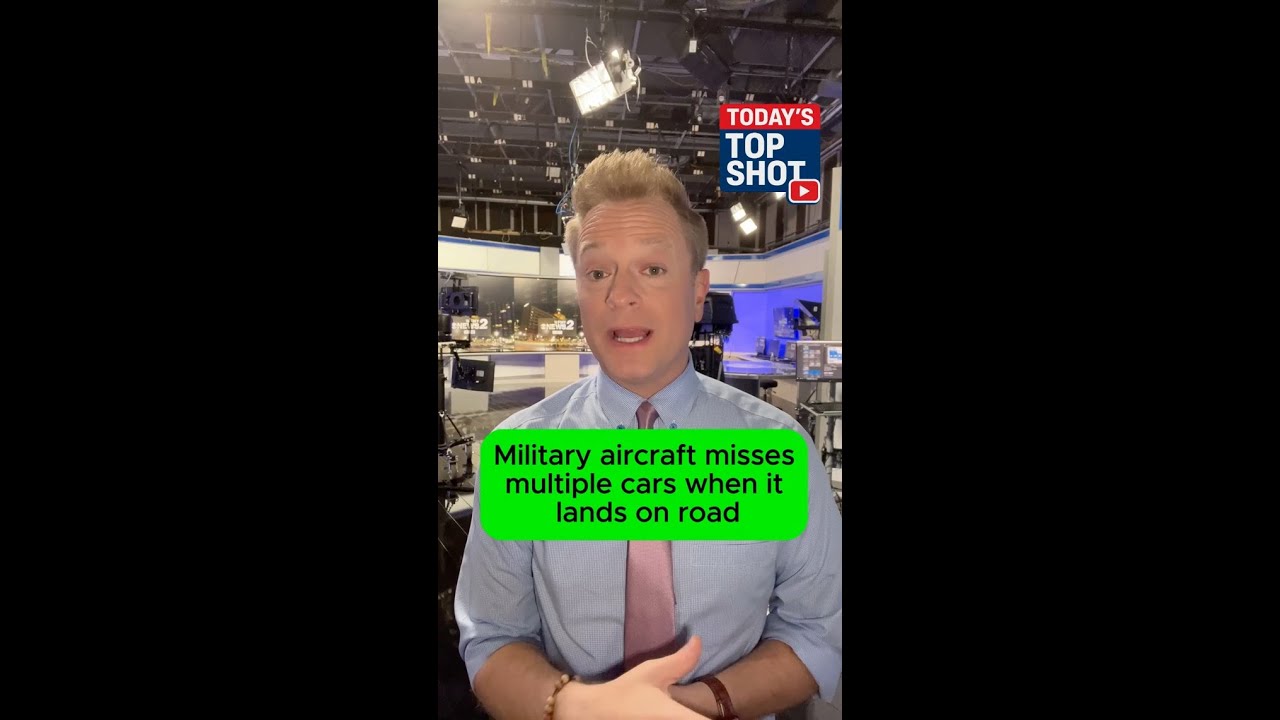 Military aircraft narrowly misses cars as it lands on road