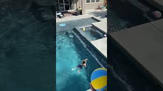 Two Boys Land Balls in a Hoop Across the Pool While Jumping Into Water