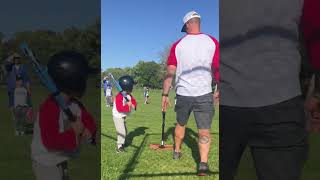 Boy hits baseball from batting tee then ball hits boy playing defense on head