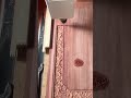 Carving intricate floral patterns on a large wooden surface using a CNC router machine in a workshop